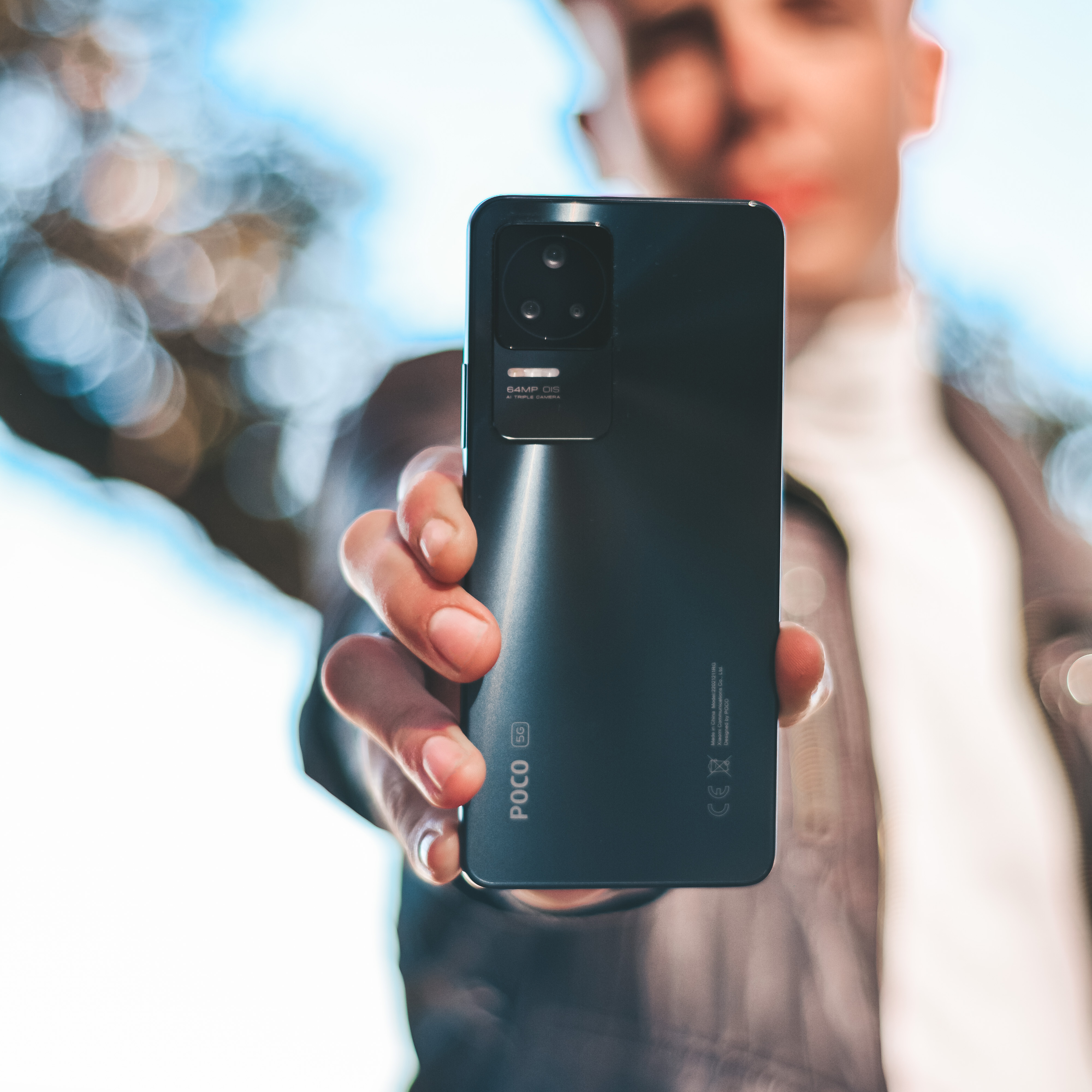Créateur tech présentant le smartphone POCO F4 GT face caméra