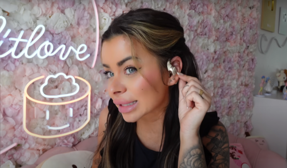 Créatrice testant les écouteurs open-ear Shokz OpenFit en intérieur
